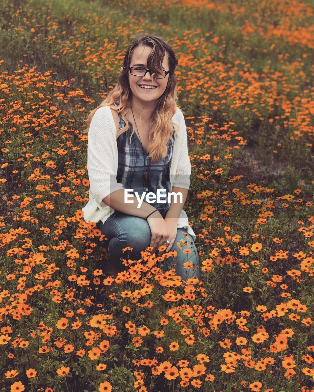 Smiling young woman sitting on field