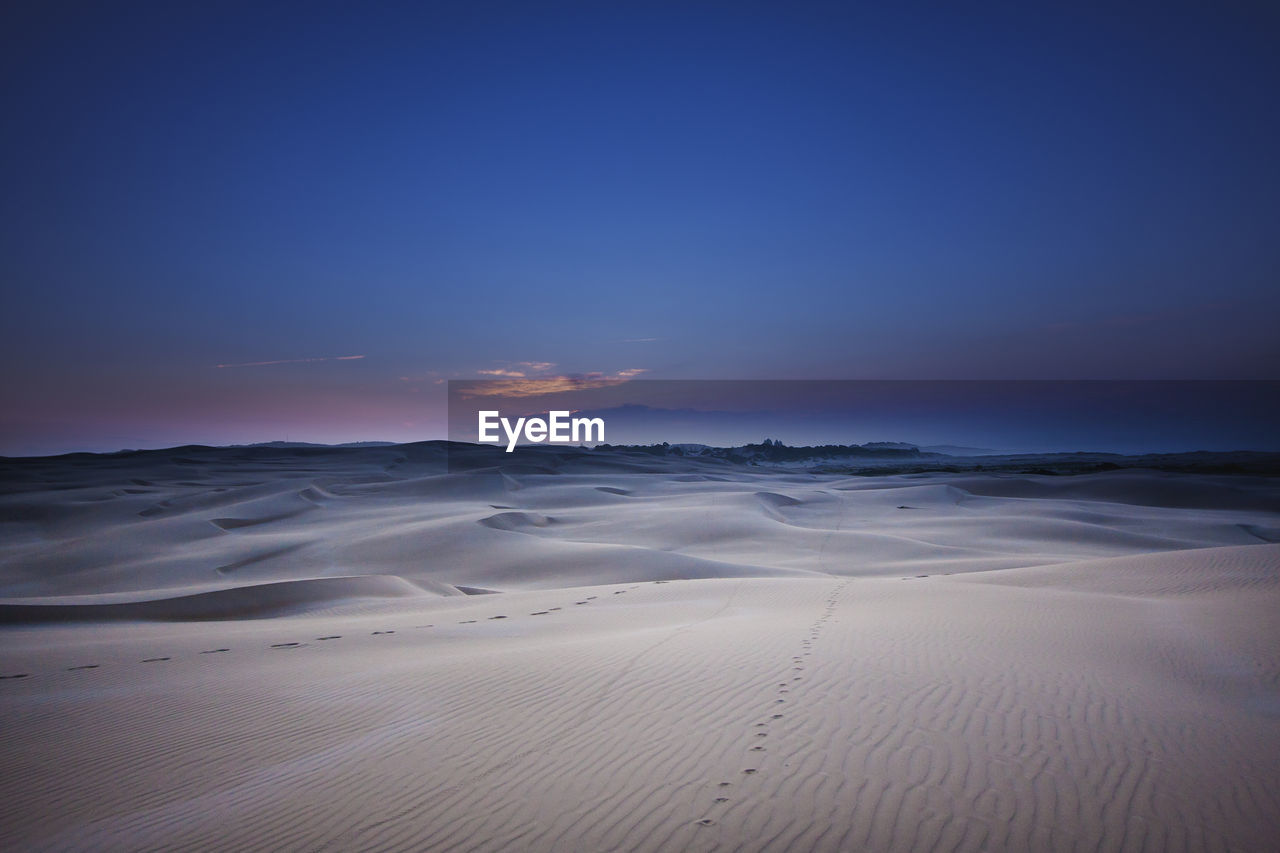 Scenic view of desert against sky during sunset