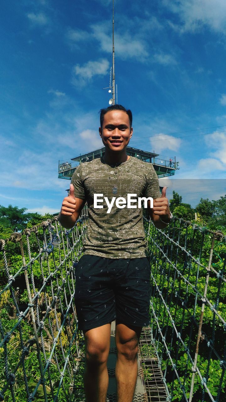 Full length of young man standing against sky