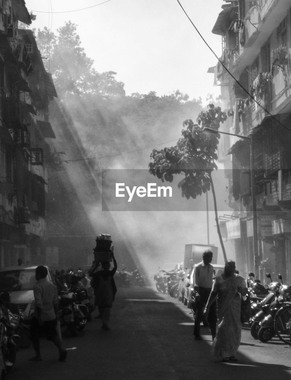 People walking on street amidst buildings in city