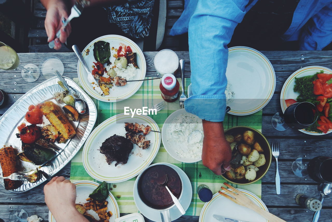 Cropped image of people having food at table