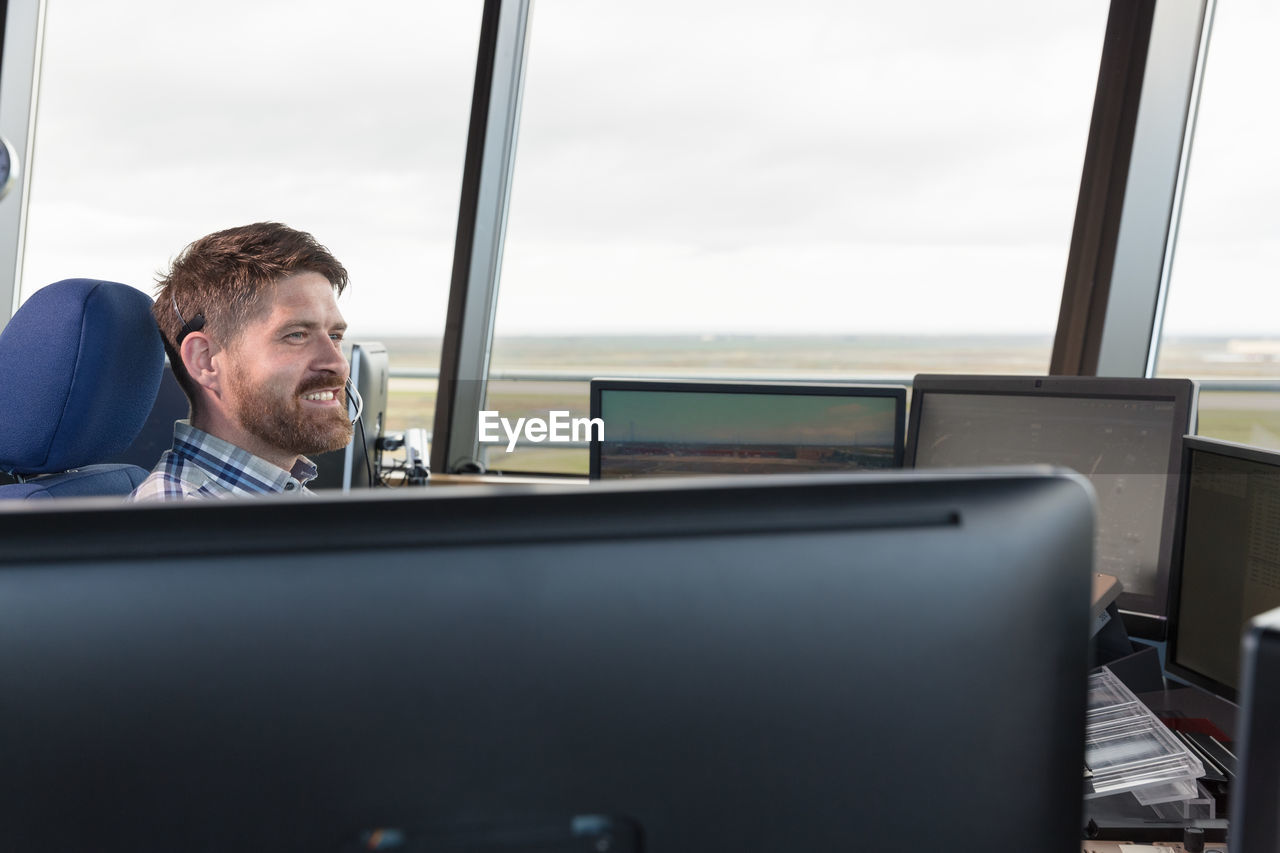 Bearded dispatcher controlling flights in airport