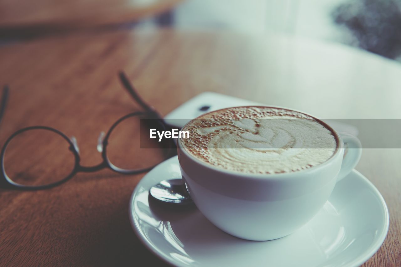 CLOSE-UP OF CAPPUCCINO COFFEE ON TABLE