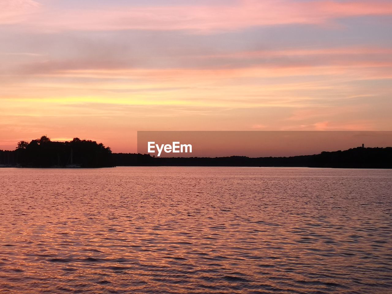 SCENIC VIEW OF LAKE AGAINST SKY DURING SUNSET