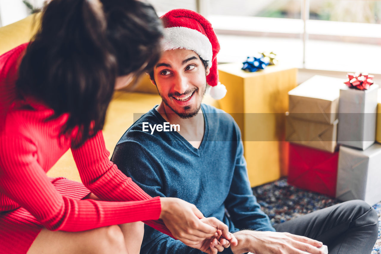 Young couple talking while sitting at home during christmas