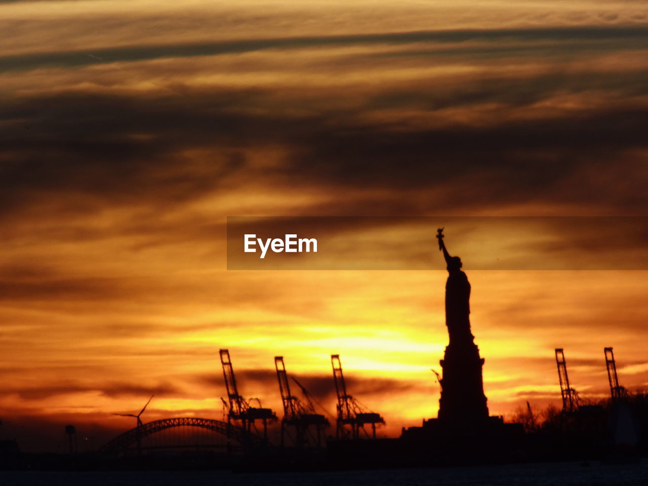 SILHOUETTE OF STATUE AT SUNSET