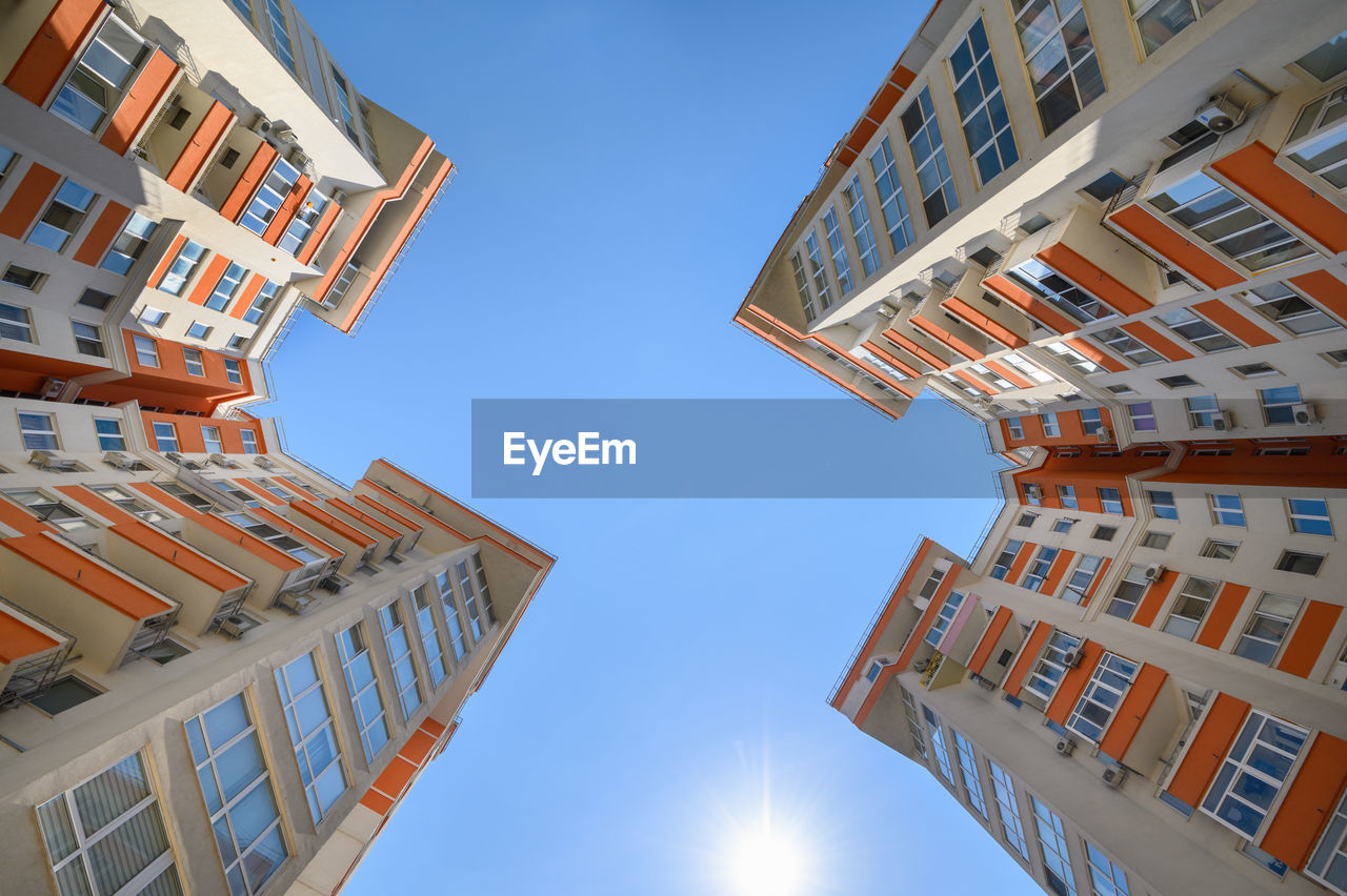 LOW ANGLE VIEW OF BUILDINGS AGAINST CLEAR BLUE SKY