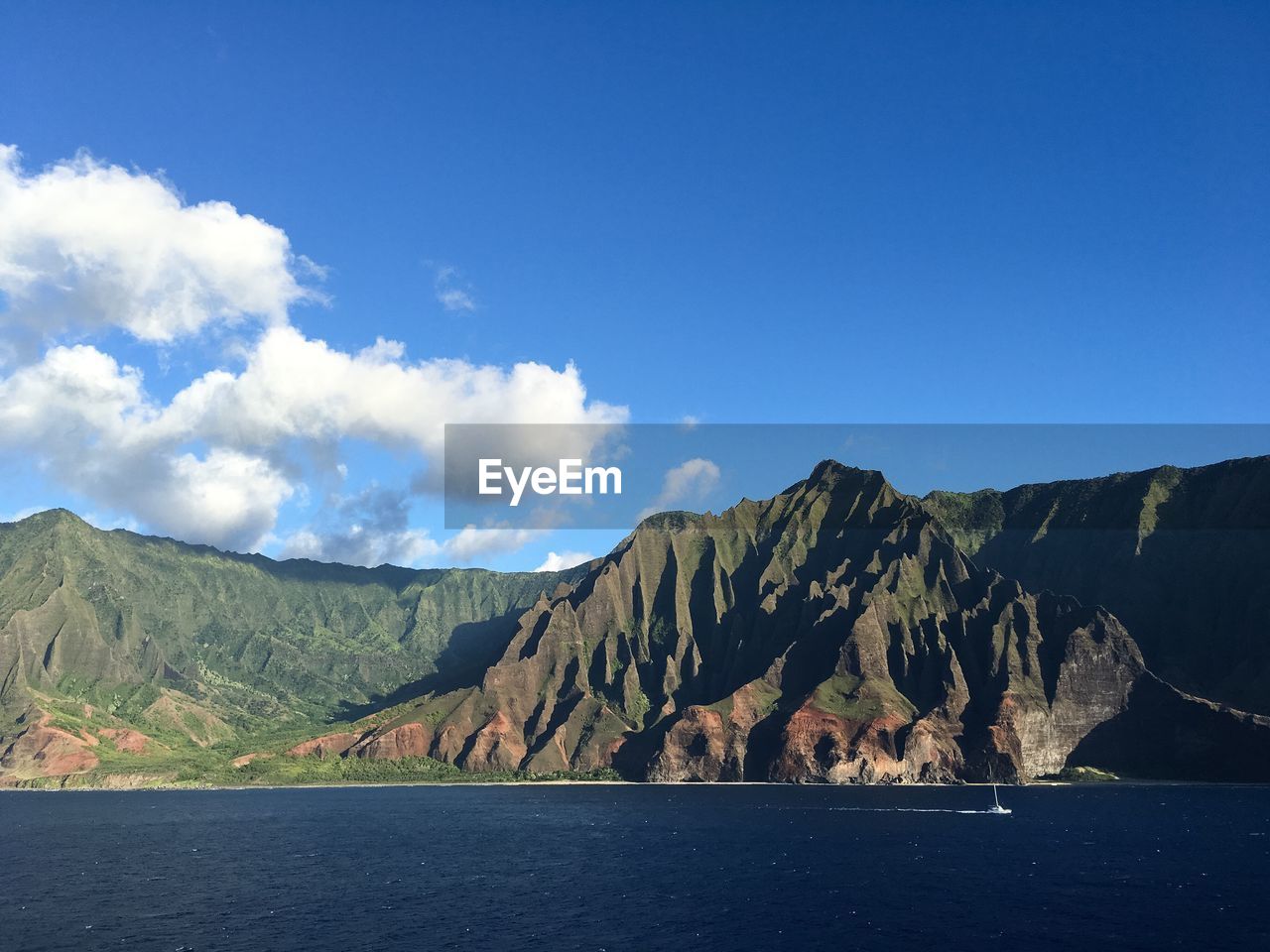 Scenic view of lake and mountains against blue sky