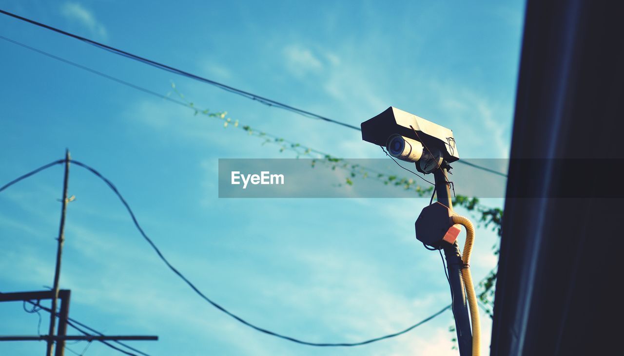 Low angle view of a security camera against sky