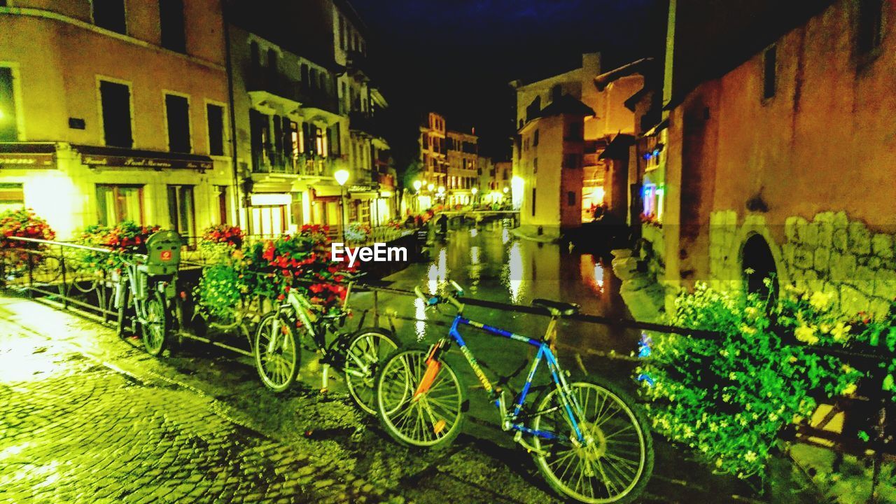 BICYCLE PARKED ON FOOTPATH BY CANAL IN CITY