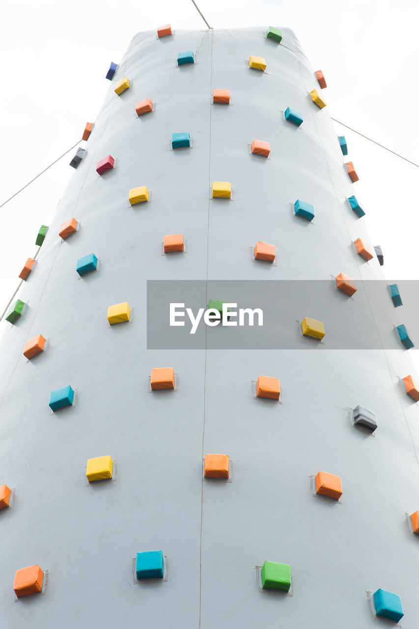 Low angle view of climbing wall against sky