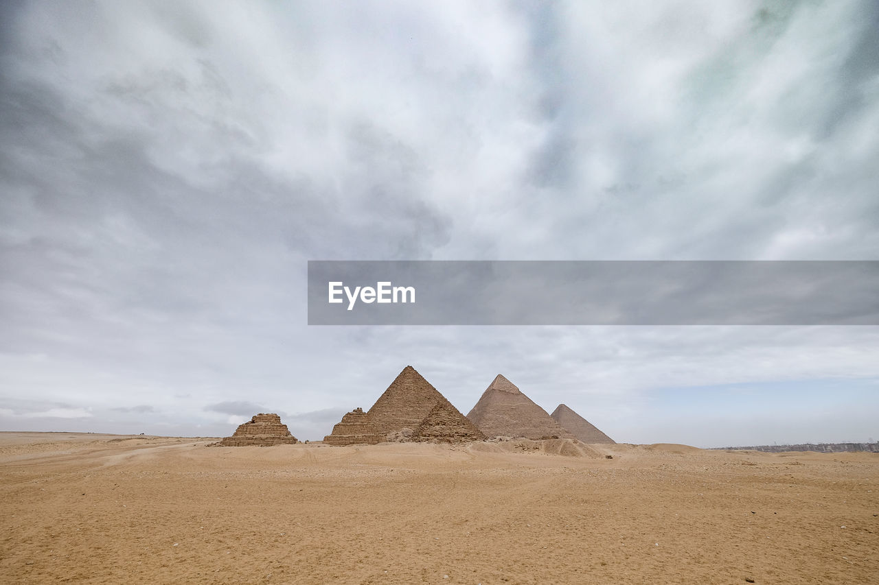 Egyptian pyramids against cloudy sky