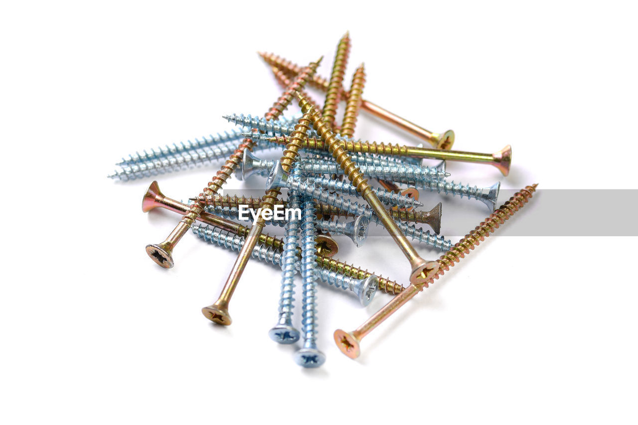 High angle view of screws against white background