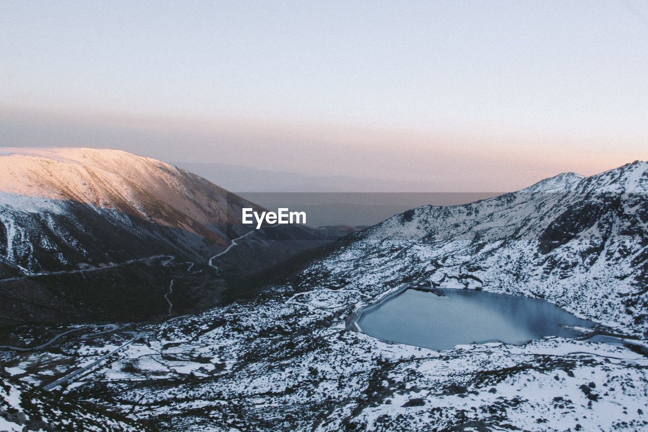 High angle view of snowcapped mountains and lake against sky