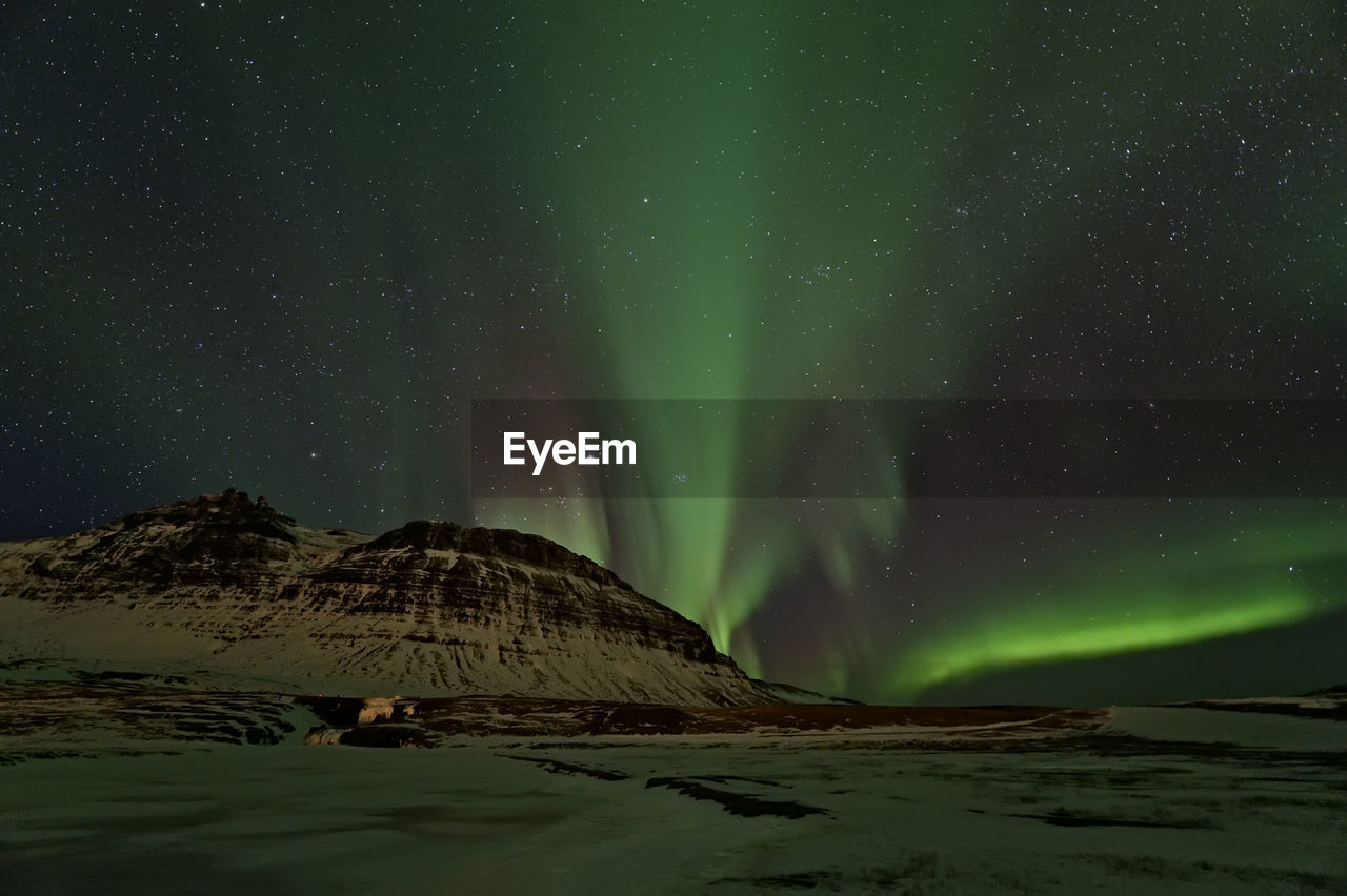 Low angle view of aurora borealis at night during winter