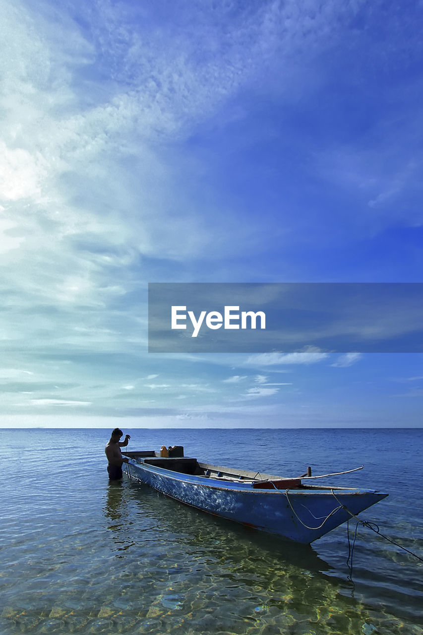 MAN IN SEA AGAINST SKY