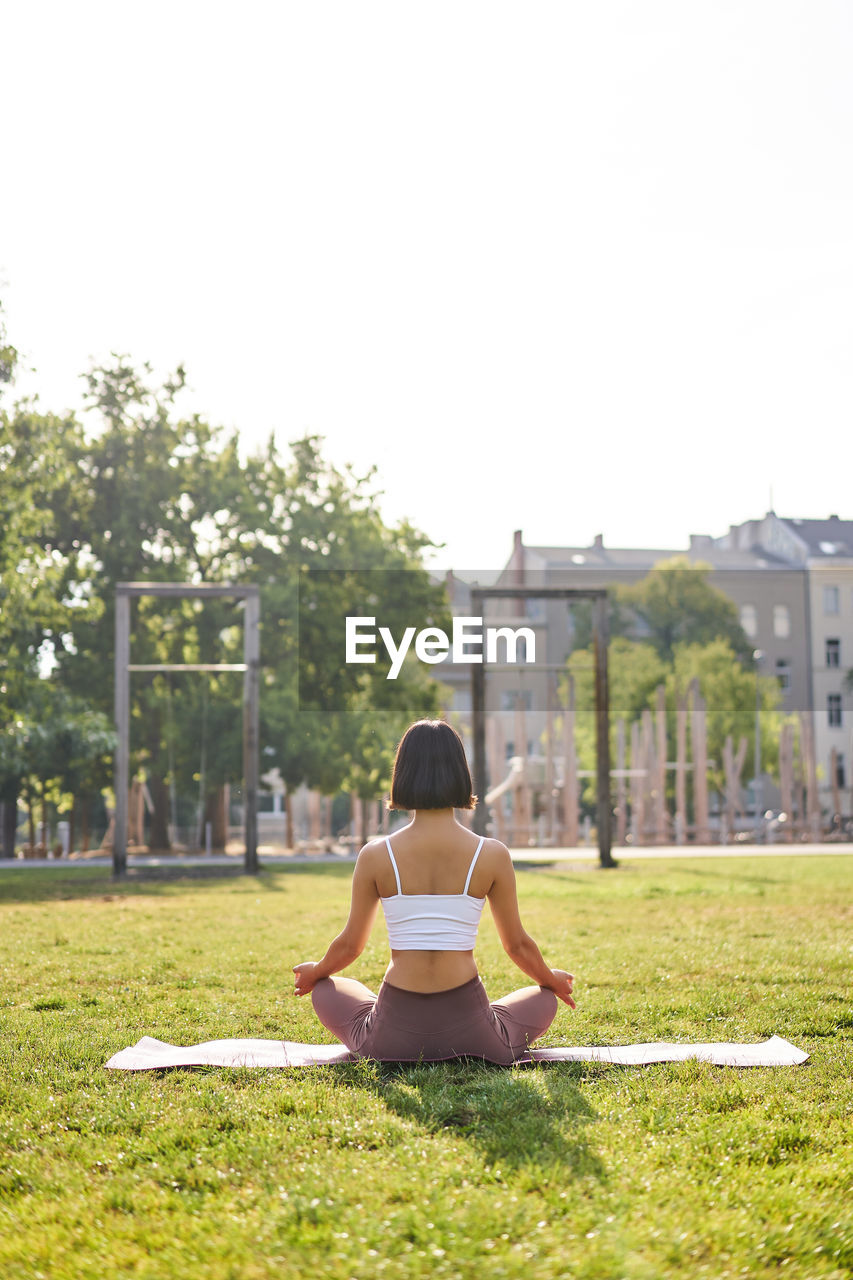 rear view of woman sitting on grass