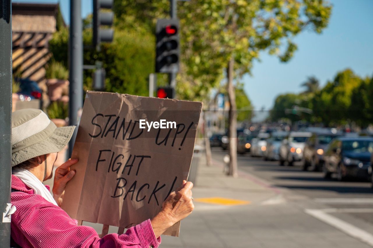 Woman holding a protest sign on a street