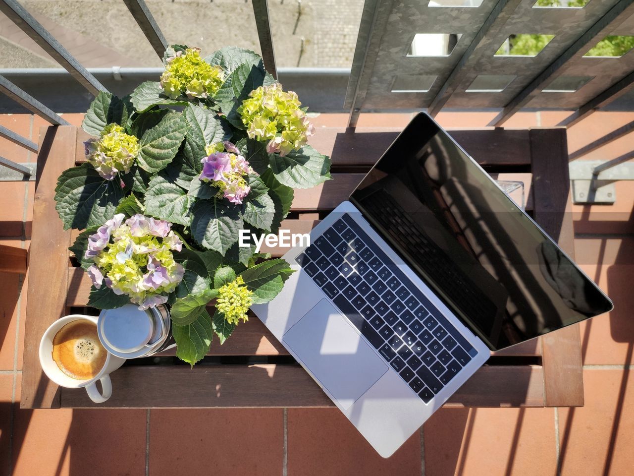 High angle view of flower and laptop on balcony table