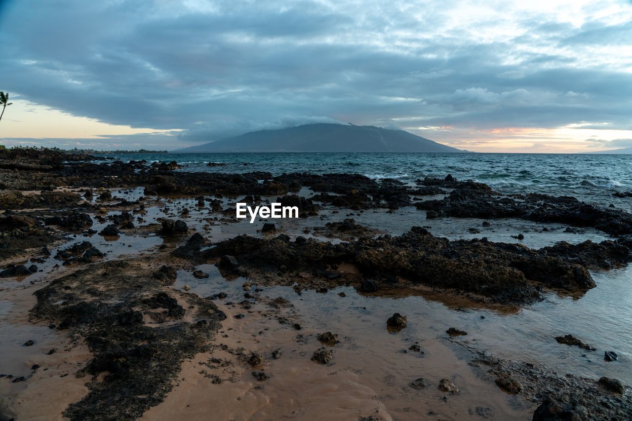 SCENIC VIEW OF BEACH AGAINST SKY DURING SUNSET