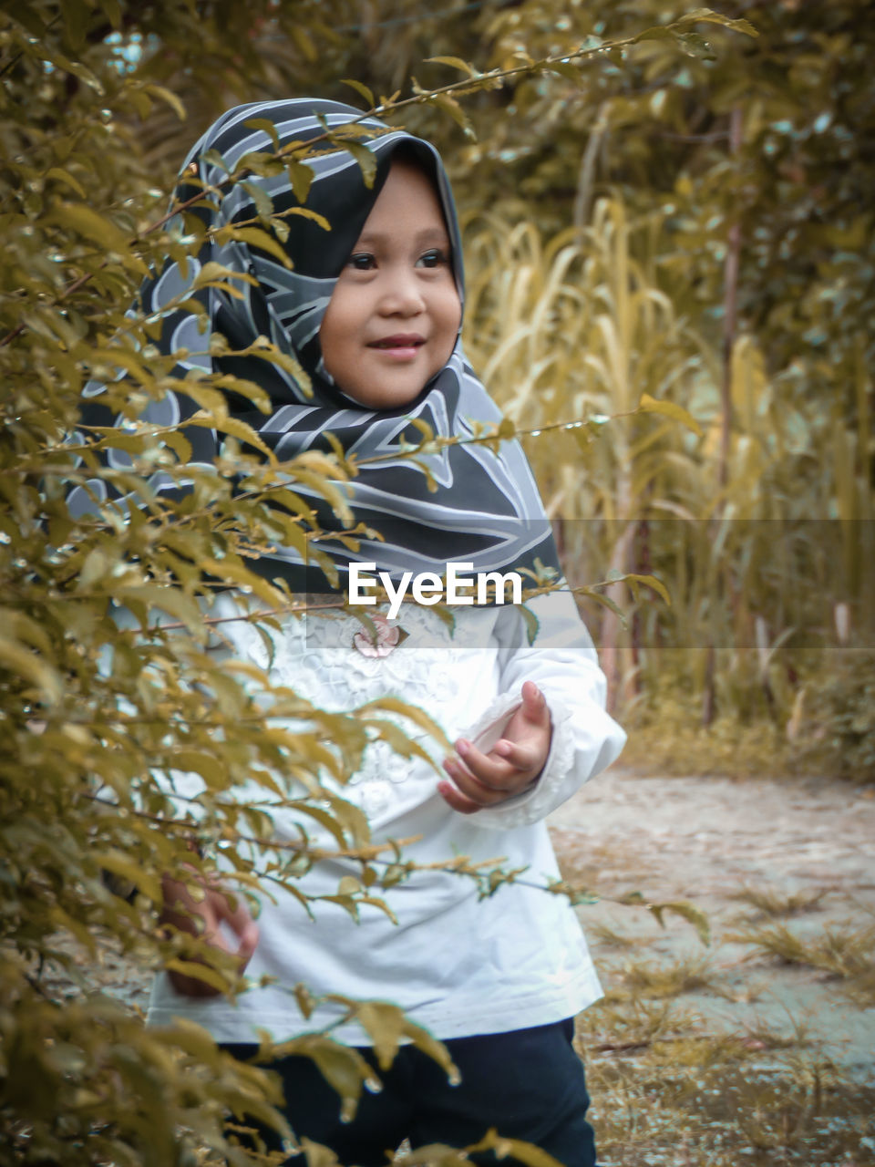 Portrait of smiling girl standing against plants