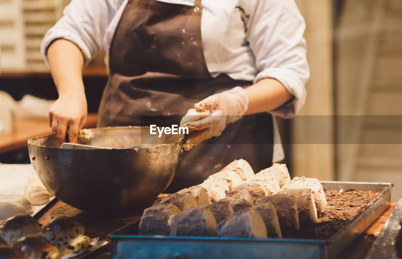 Midsection of female chef preparing food on table