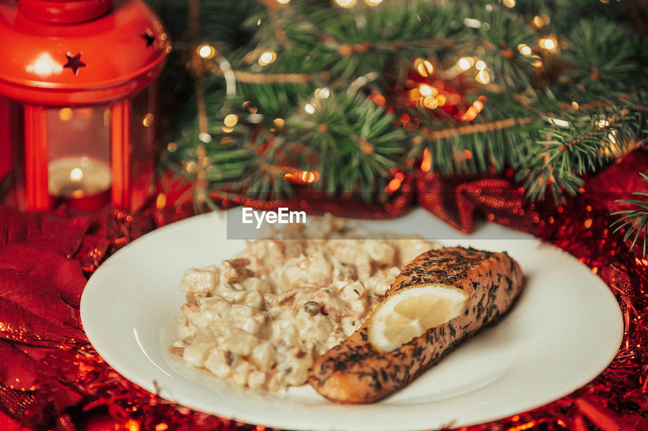 Traditional christmas food, salmon with potato salad on the table, food concept