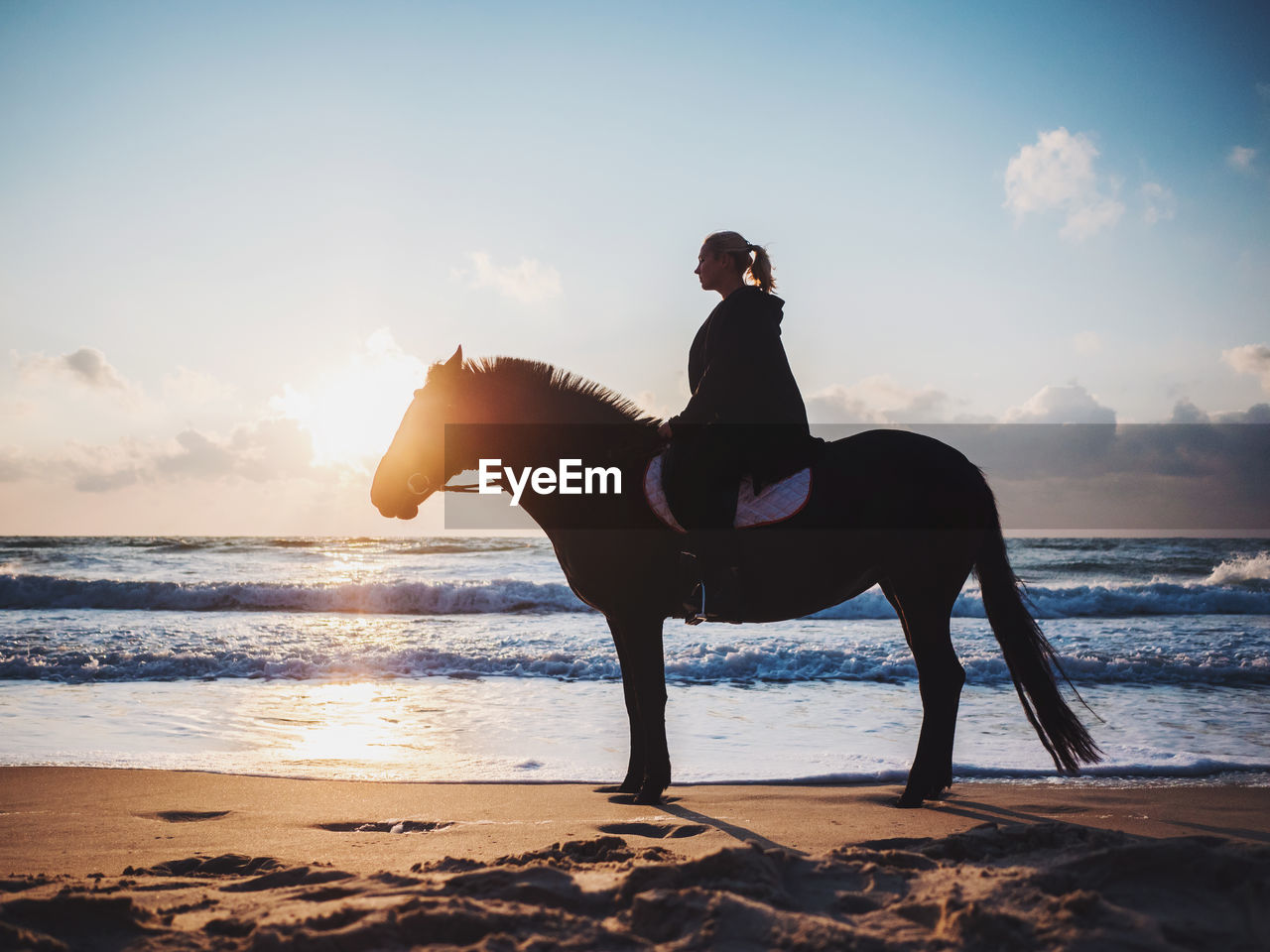 Woman horseback riding at beach
