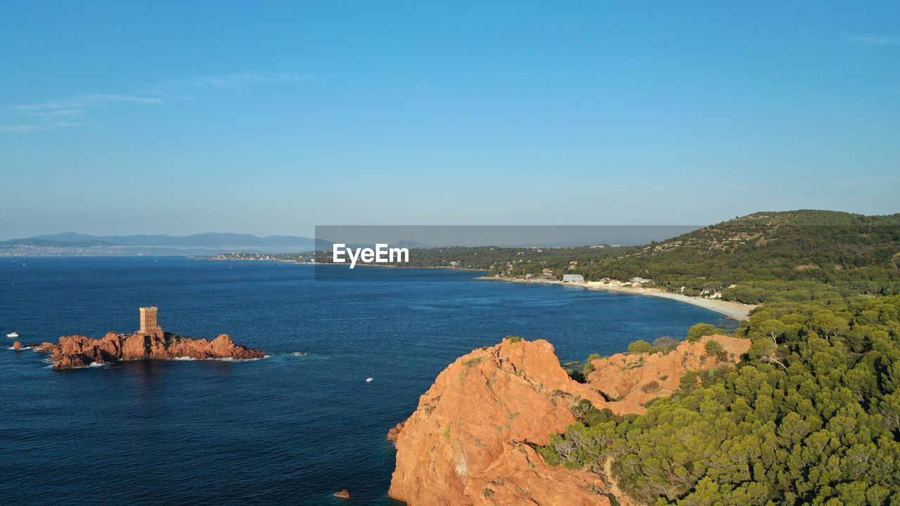 SCENIC VIEW OF SEA AND MOUNTAINS AGAINST BLUE SKY