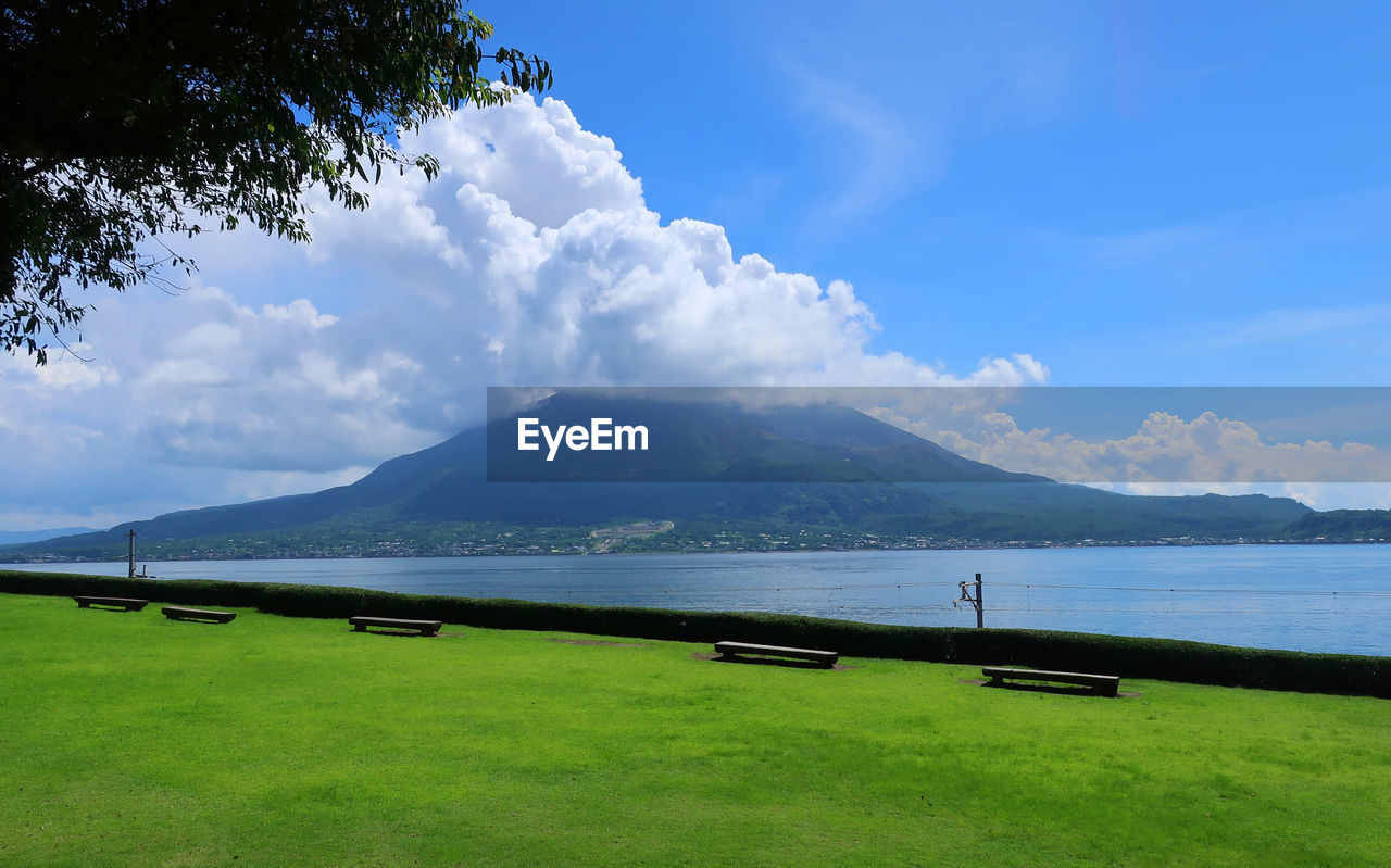 Scenic view of land by lake against sky