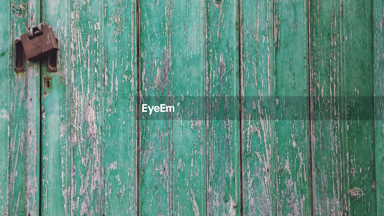 CLOSE-UP OF GREEN DOOR AGAINST BLUE WALL