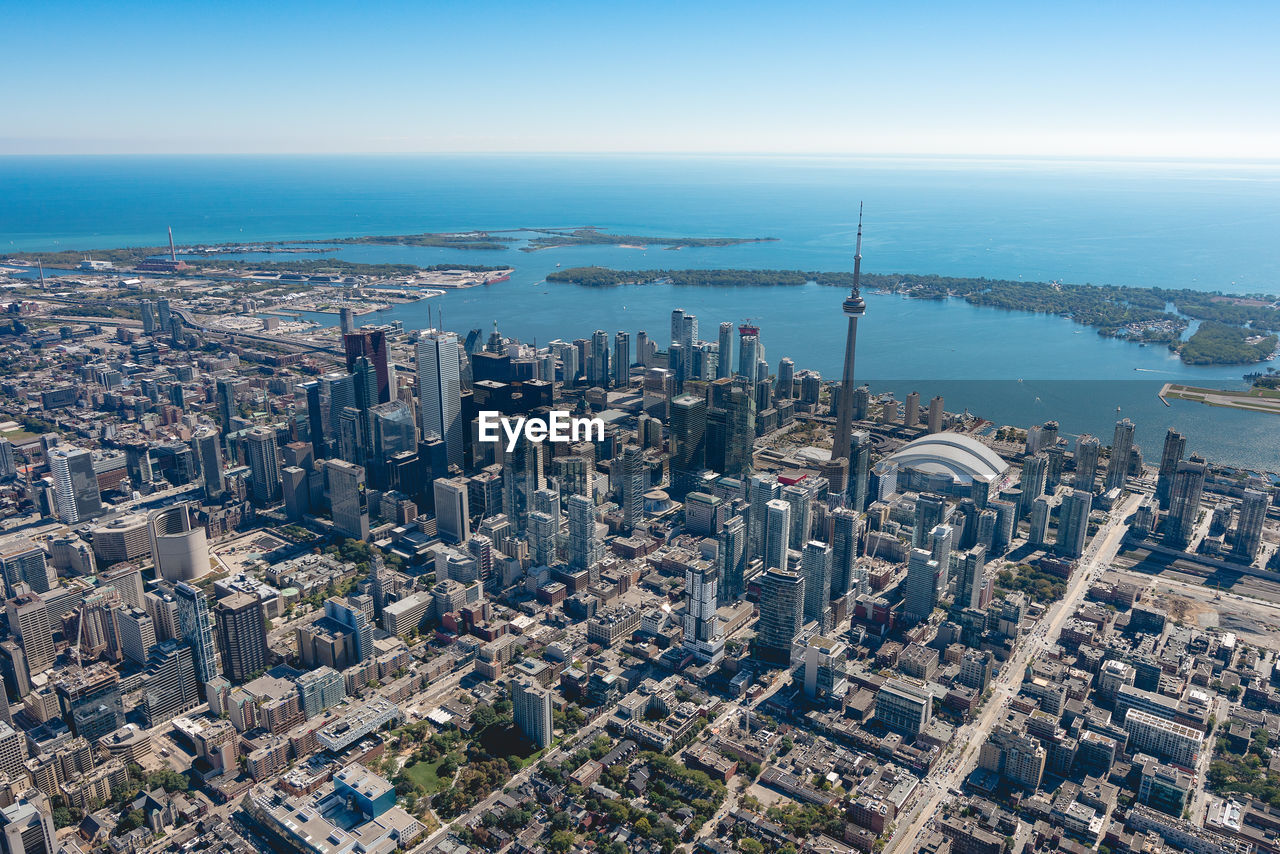 Aerial view of cityscape by sea against sky