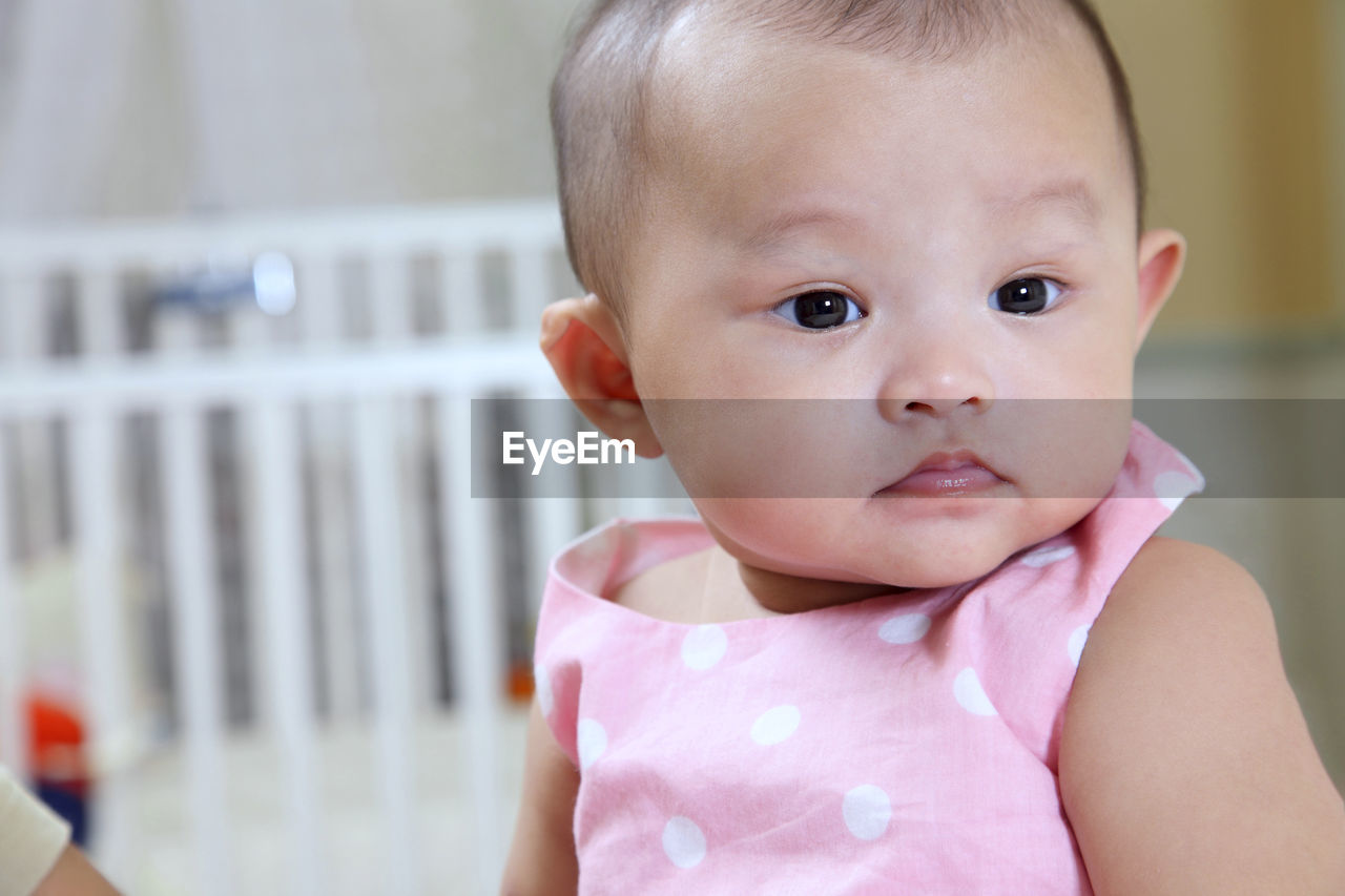 Close-up of cute baby girl at home