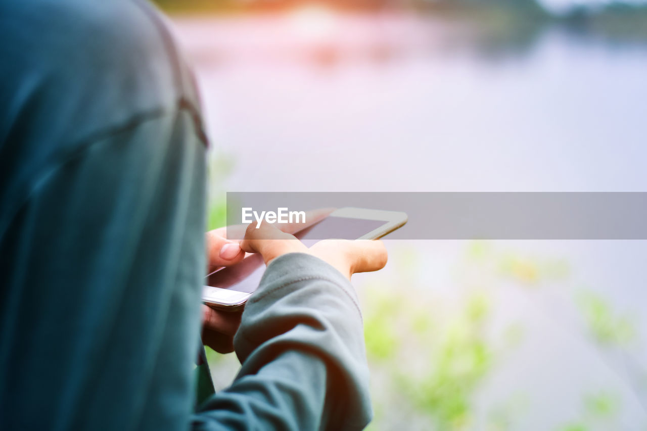 Midsection of man using mobile phone