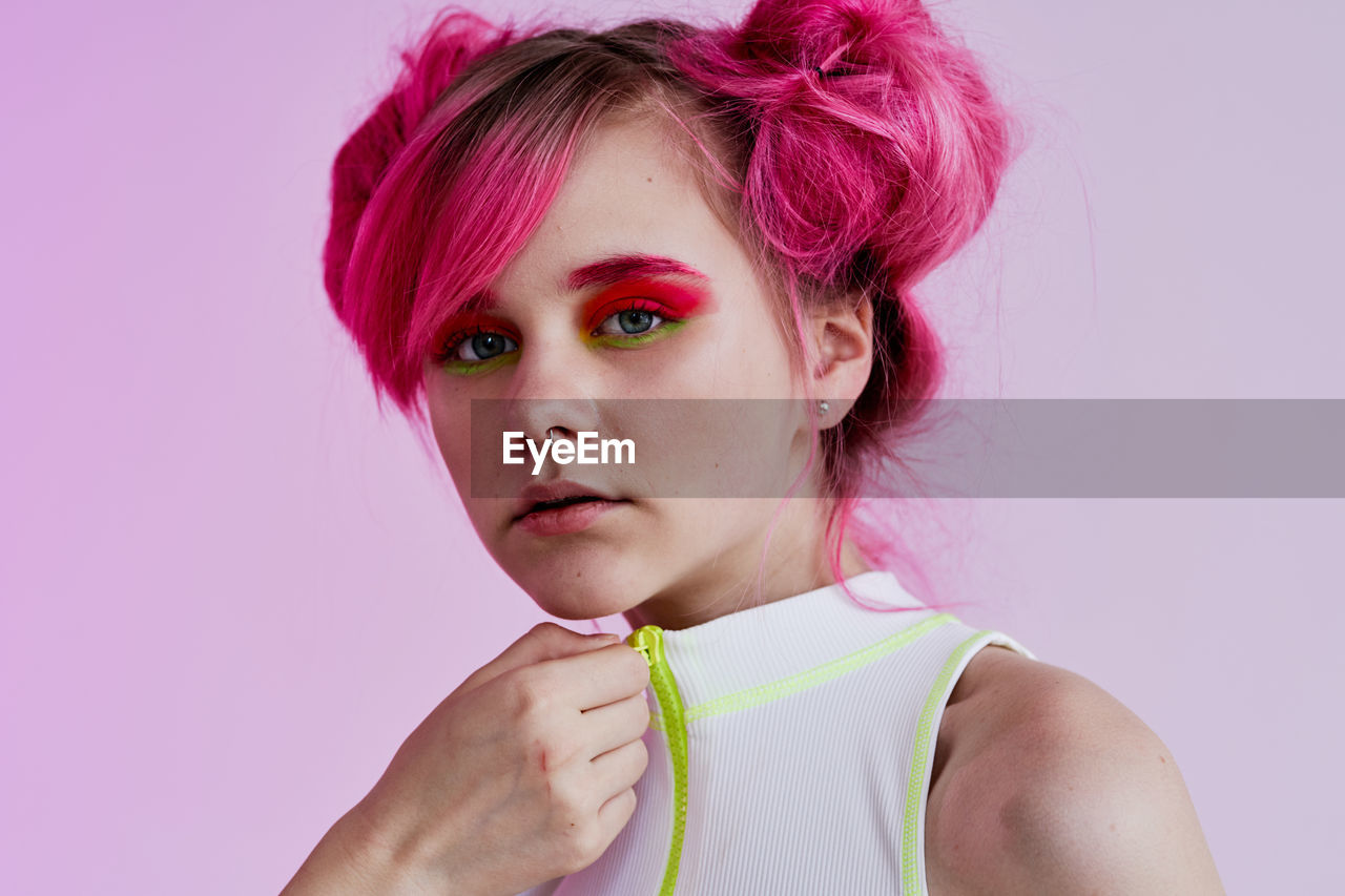 portrait of young woman with eyes closed against blue background