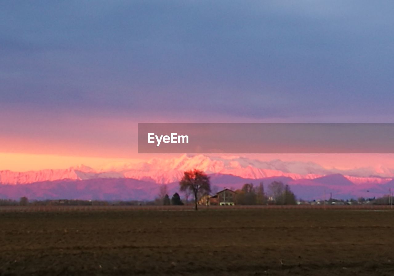 SILHOUETTE OF PEOPLE ON FIELD AGAINST SKY DURING SUNSET