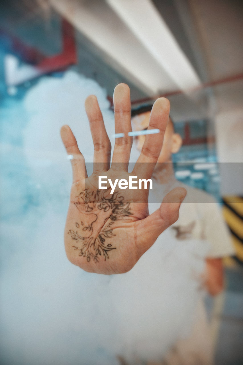 Close-up of human hand with pattern seen through glass