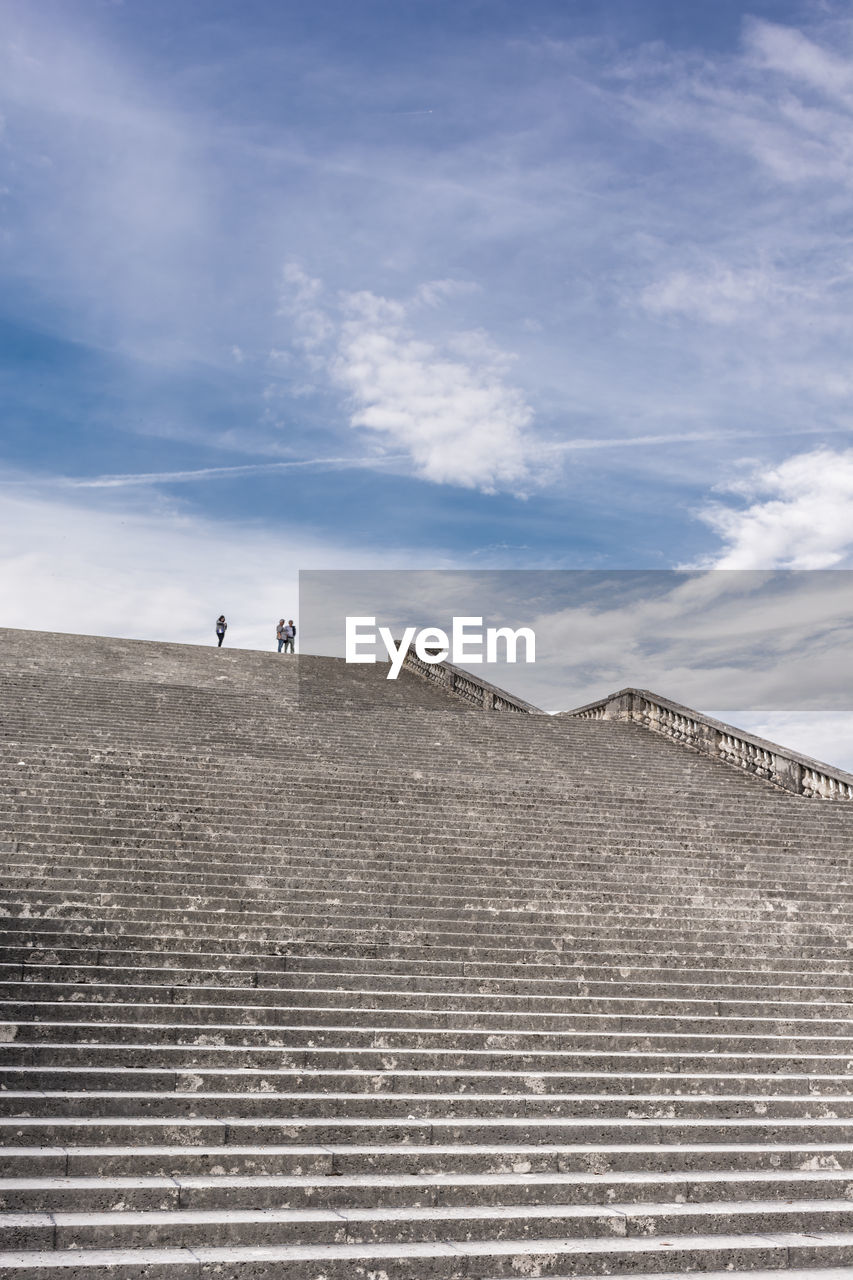 People on staircases against sky