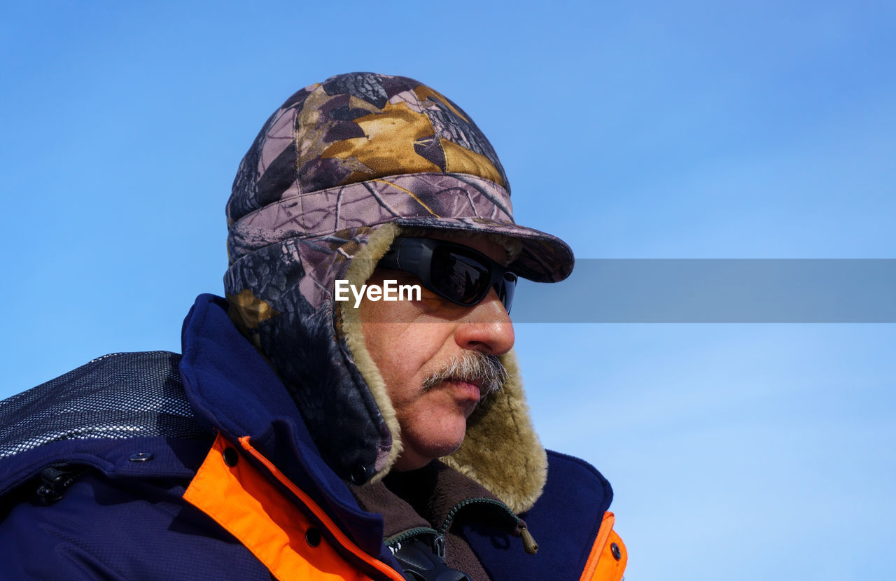 Close-up of man wearing sunglasses against sky