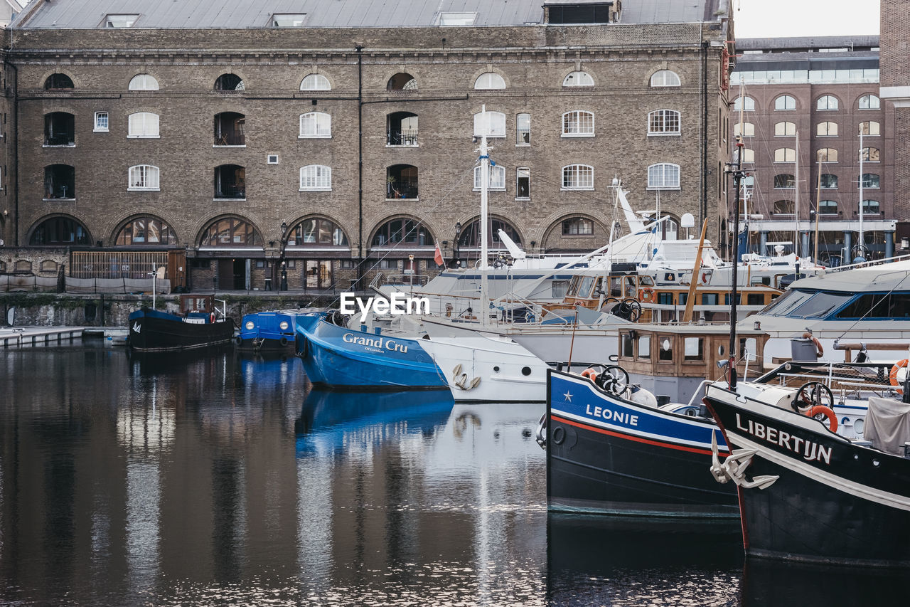 SAILBOATS MOORED IN CANAL BY BUILDINGS IN CITY