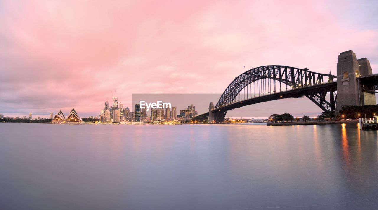 Sydney harbor bridge over parramatta river in city during sunset