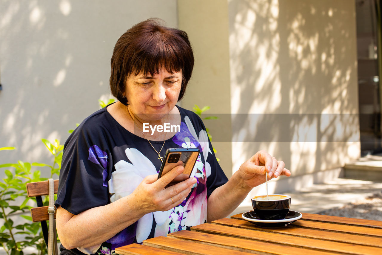 YOUNG MAN USING PHONE ON TABLE