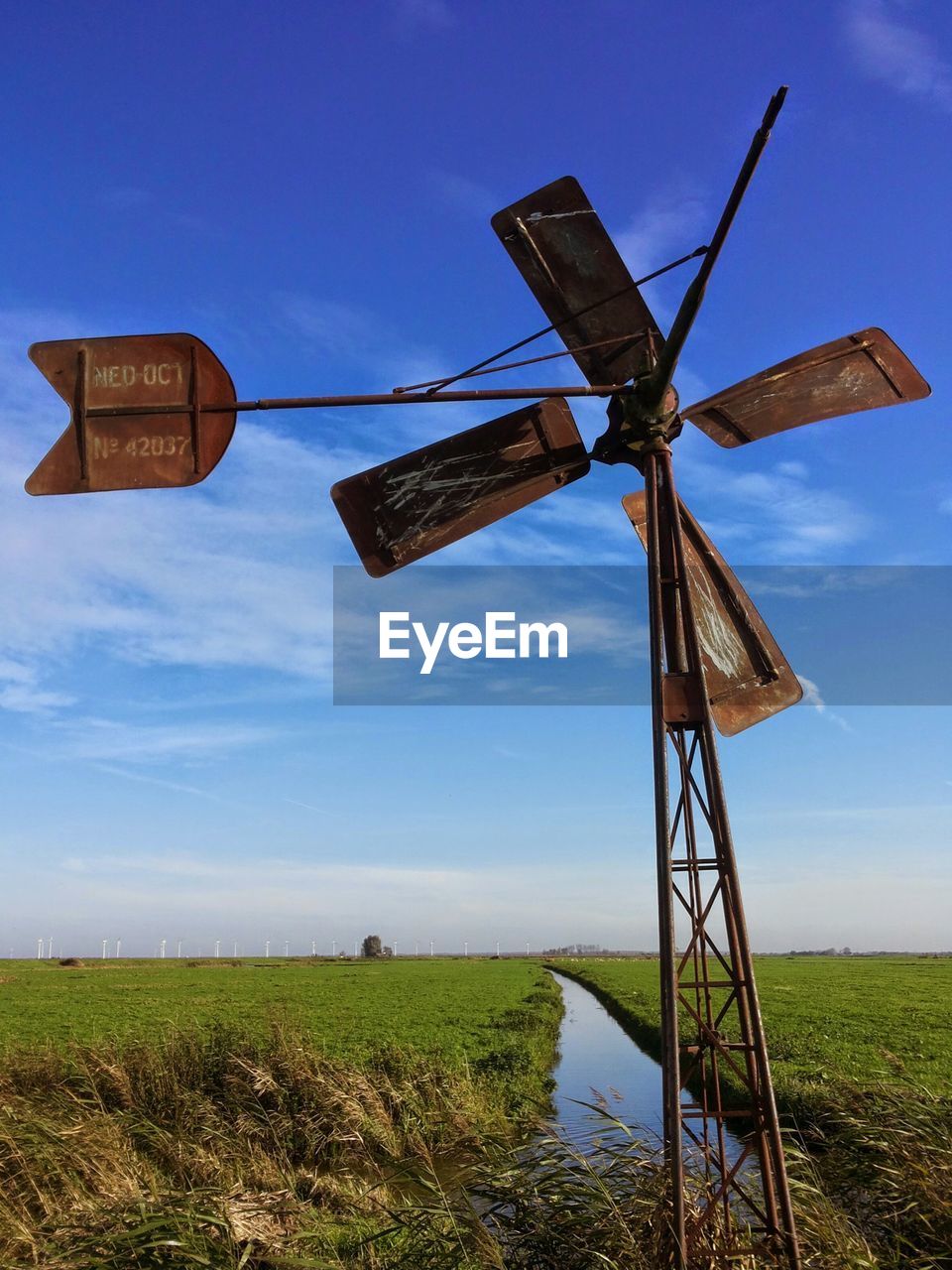 Traditional windmill on field against sky