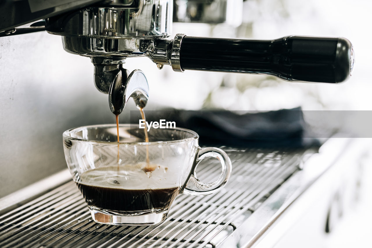 Close-up of coffee pouring in glass