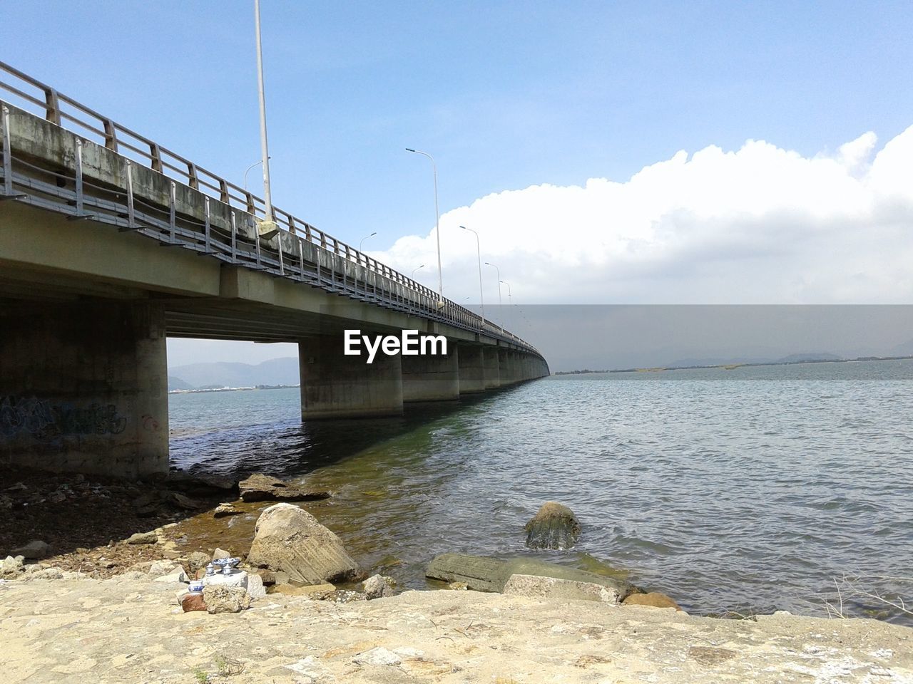 LOW ANGLE VIEW OF BRIDGE OVER SEA AGAINST SKY