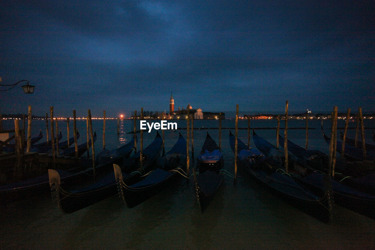 Gondolas on grand canal in city at night