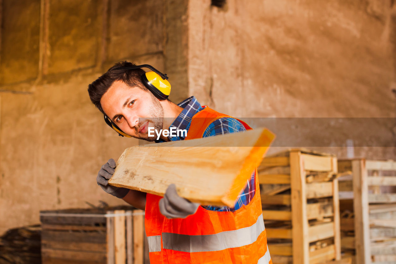 PORTRAIT OF MAN WORKING ON WOOD