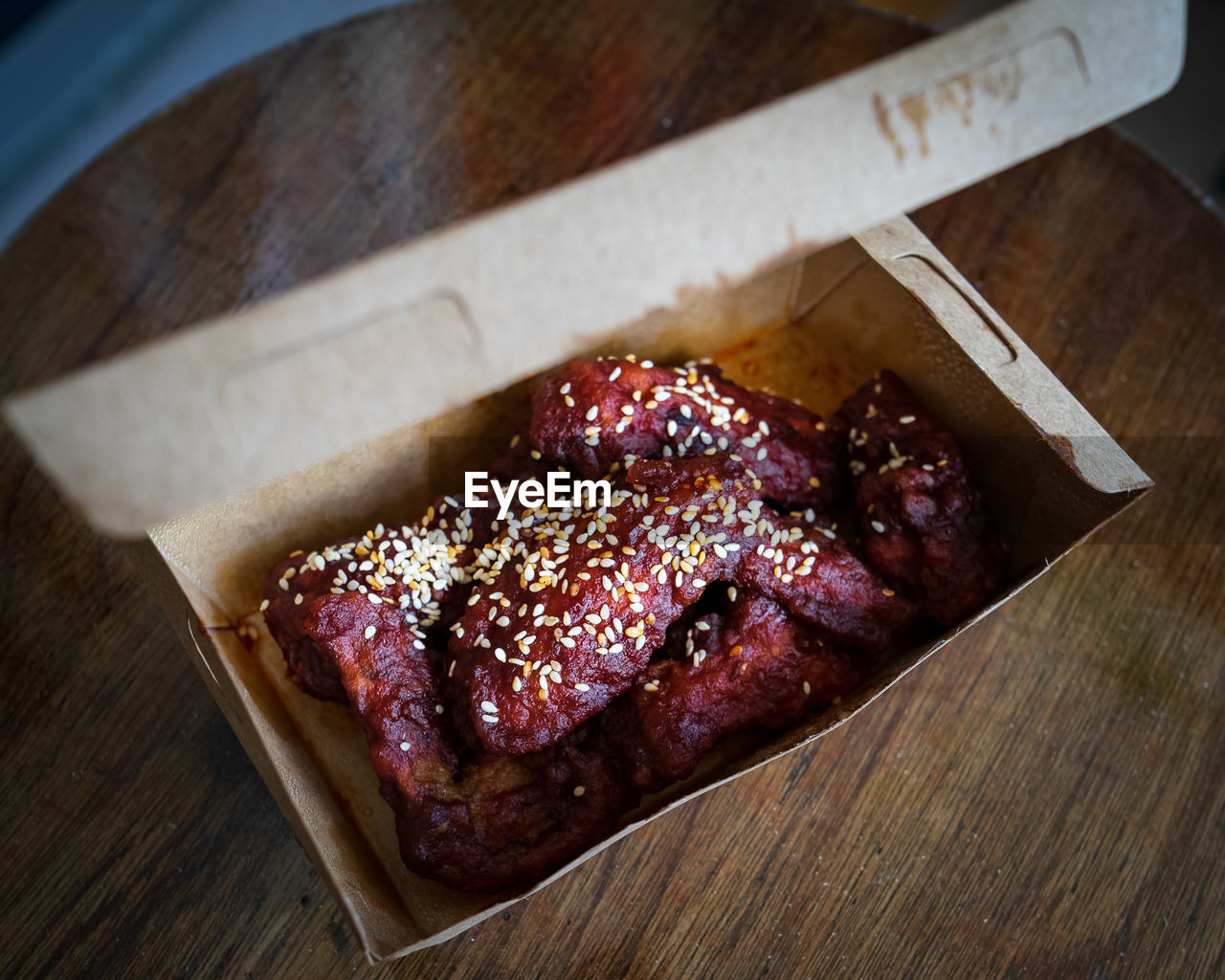 Spicy korean fried chicken wings and drummets in a take away box. traditional asian recipe.