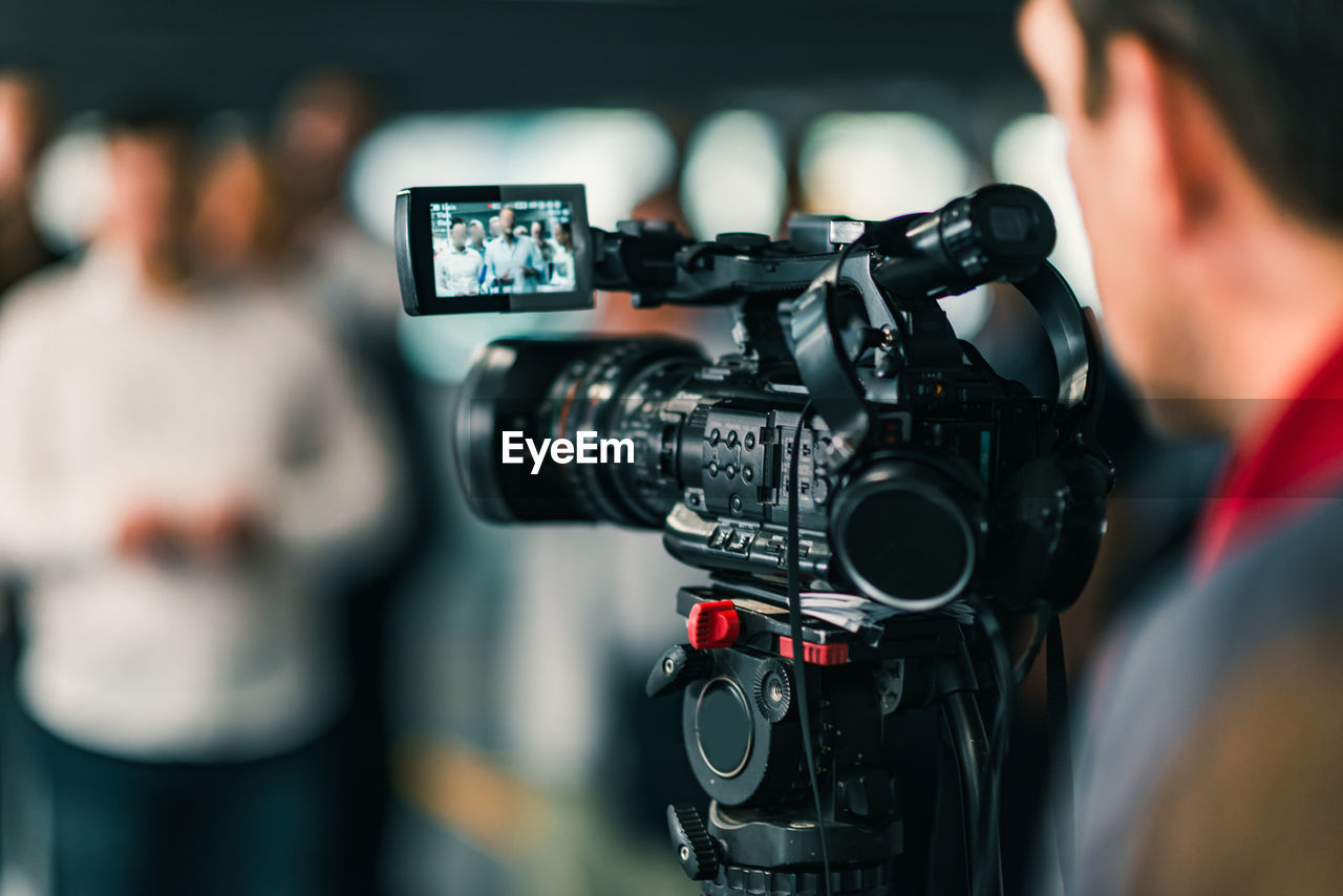 Close-up of cameraman filming in studio