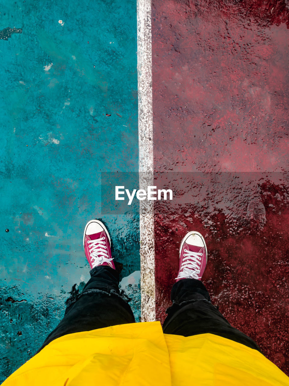 Low section of man standing at sports court during rainy season